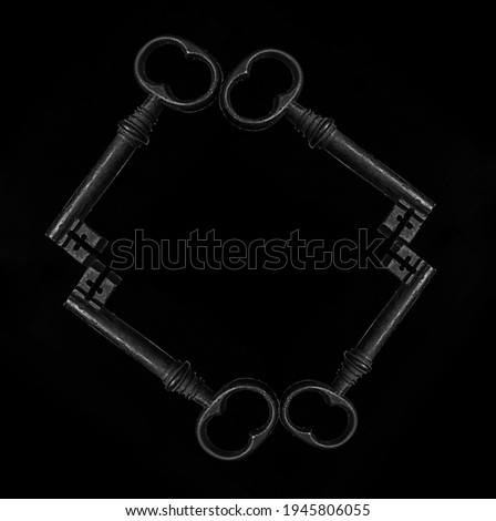 frame made from four Old metal keys isolated on black background. 