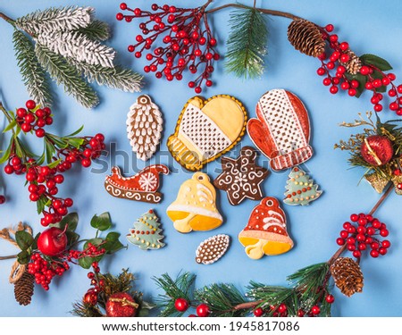 Festive Christmas and new year decorations with gift boxes and gingerbreads on blue background.
