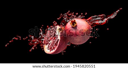 pomegranates with red juice splash on a black background