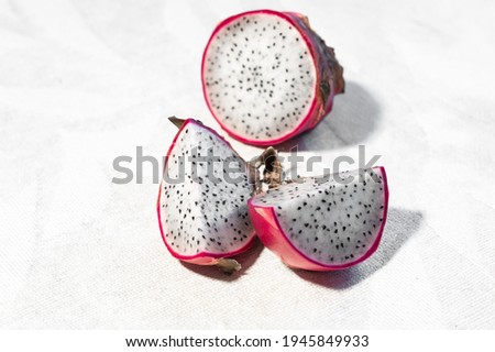 Pink dragon fruit on white background. Sunlight picture with exotic fruit. Copy space. Healthy raw vegetarian concept of food.