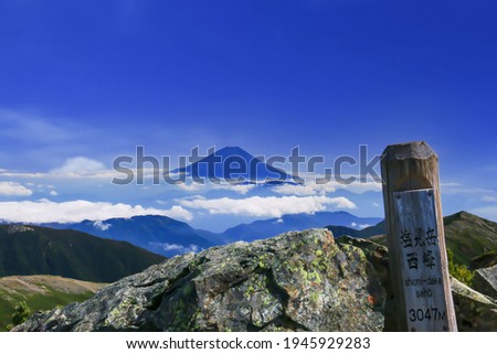 superb view of mt.fuji from the summit of Mt.Shiomi in the Southern Alps,ina city,nagano prefecture,japan.
I translate the  japanese written on the sign: Mt.Shiomi, west peak, 3014m Royalty-Free Stock Photo #1945929283