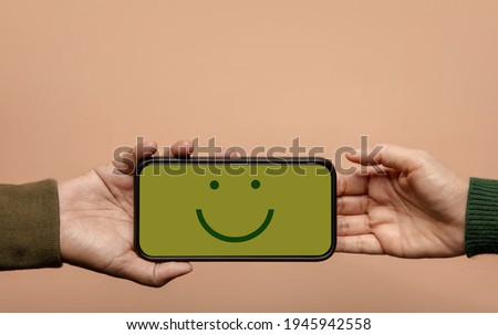Customer Experience Concept. Happy Client giving a Smiling Emoticon via Mobile Phone to Brand. Feedback on Smartphone. Positive Review. Satisfaction Survey