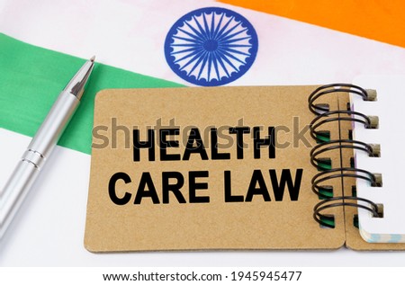 Law and justice concept. Against the background of the flag of India lies a notebook with the inscription - HEALTH CARE LAW