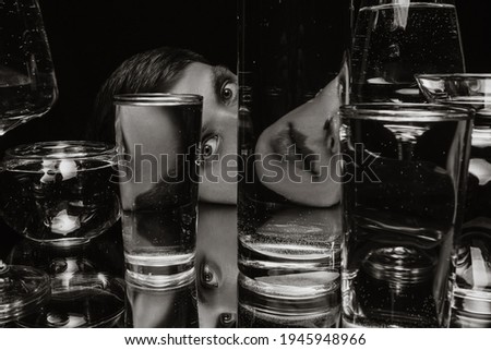 black and white surreal portrait of a man looking through glasses of water