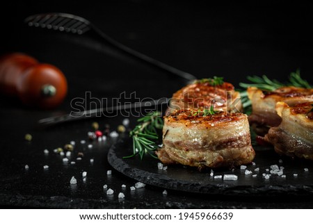 Grilled steak filet mignon wrapped bacon dark concrete background. banner, menu recipe place for text.