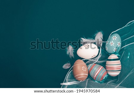 Easter banner with eggs and feathers on a blue wooden background. The minimal concept of Easter. Top view. An Easter card with a copy of the place for the text.