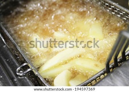 chips frying in frier Royalty-Free Stock Photo #194597369