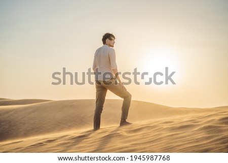 Man traveling in the desert. Sandy dunes and blue sky on sunny summer day. Travel, adventure, freedom concept. Tourism reopens after quarantine COVID 19