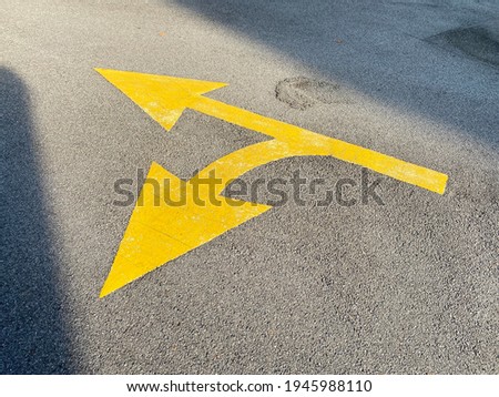 View of a yellow directional road arrow painted with thermoplastic material