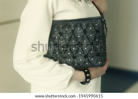 blue leather bag and bracelet close up photo with human hands 