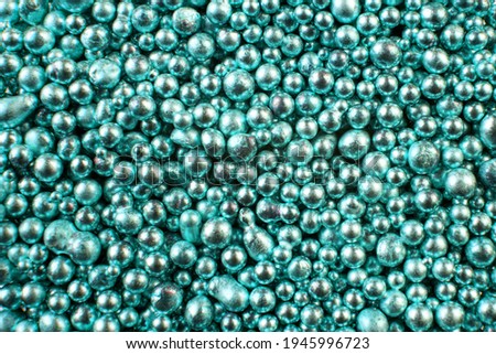A background of many shiny metallic balls of turquoise color.