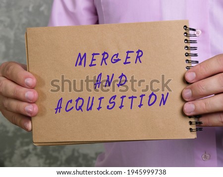 Financial concept about MERGER AND ACQUISITION with phrase on the sheet. 

