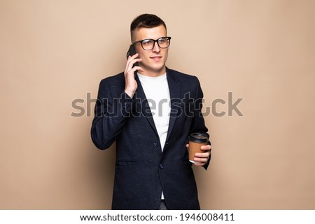 Business man negotiating on phone, isolated on beige background