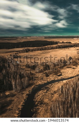 Forest landscape with sky, field and river. Wild European nature. Beautiful sky. Top view, aerial photography. Fantasy landscape.