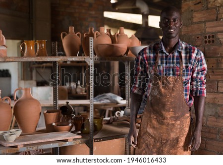 Portrait of professional African American male potter standing in pottery workshop
