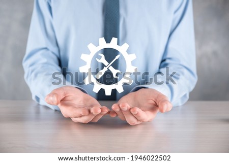 Businessman holding gear icon with tools.Gearing.Concept of target focus digital diagram,graph interfaces,virtual UI screen,connections netwoork