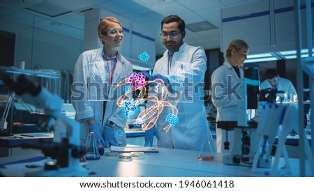Female and Male Medical Research Scientists Use Futuristic Virtual Interface of a Gene Editing Software in a Modern Science Laboratory. Concept of Using Futuristic Technologies.