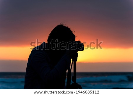 silhouette of woman photographer at sunset