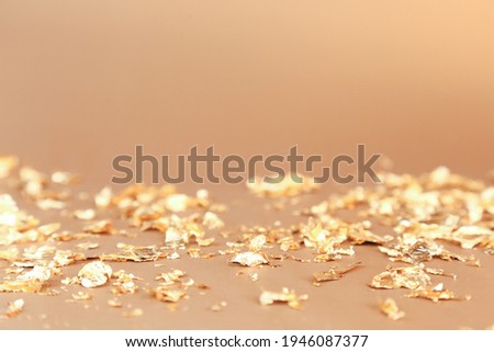Cosmetics product advertising backdrop. Pieces of gold paper firecracker on golden background. Empty place to display product packaging, new Year party. Showcase mockup.  