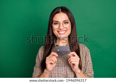 Photo of girl hands hold black credit card beaming smile wear spectacles plaid shirt isolated green color background