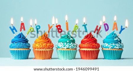 Blue and orange birthday cupcakes spelling happy birthday 