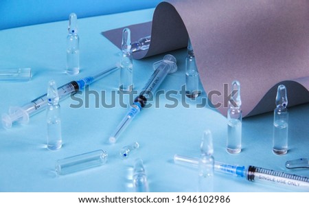 Ampoules for injection and syringes on a blue background, the concept of medicine and vaccination
