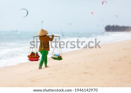 Vietnamese woman selling Fruits at Mui Ne beach. Vietnam.  Mui Ne white sandy beach in Vietnam.