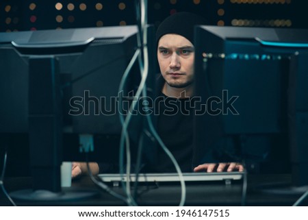 Young professional male hacker using keyboard typing bad data into computer online system and spreading to global stolen personal information. Wanted programmer coding virus ransomware using computers