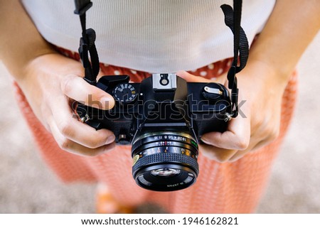 Retro SLR camera in a young woman hands