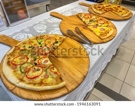 Big size bell pepper and pepperoni pizza on wooden round tray