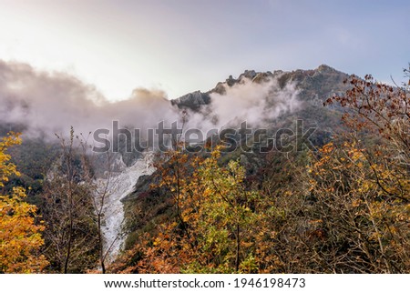 View of the Cervaiole marble quarry at sunset, partially covered by a low cloud, Seravezza, Apuan Alps, Italy