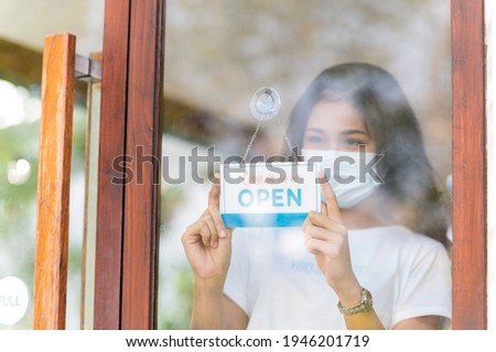 Young woman wearing protective face mask welcome open shop