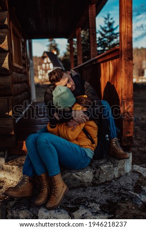A loving man and woman are sitting on the balcony of their cottage