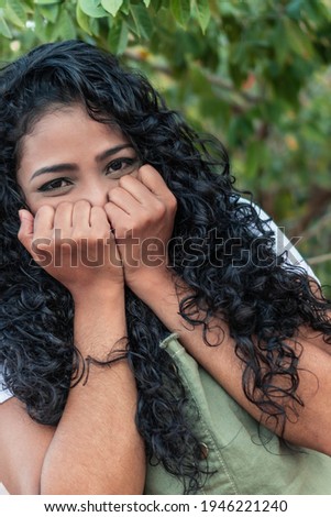 Surprised young woman with hands over her mouth outdoor