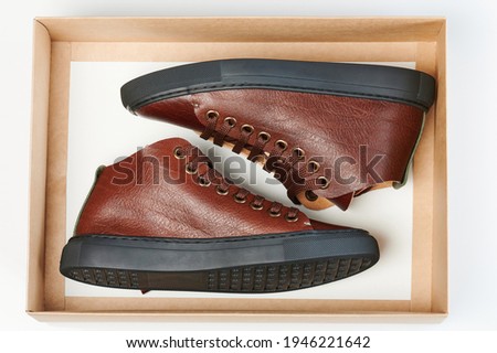 Modern brown leather casual shoes in paper open box isolated