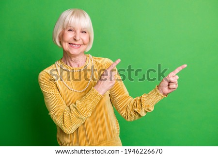 Photo of cheerful lady hands fingers direct empty space wear yellow velvet shirt pearl necklace isolated green background