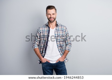 Portrait of attractive cheerful content guy holding hands in pockets wear checked shirt isolated over gray pastel color background Royalty-Free Stock Photo #1946244853