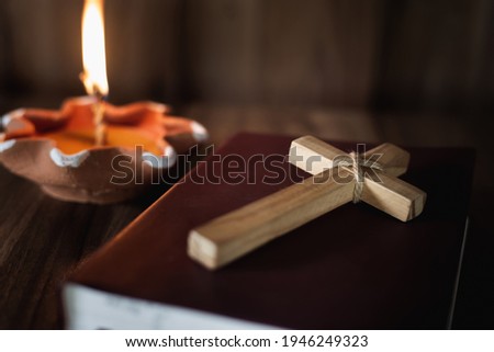 The crucifix lay on the bible. While there are candles that are illuminating Christian religious concepts, the crucifixion of faith and faith in God.