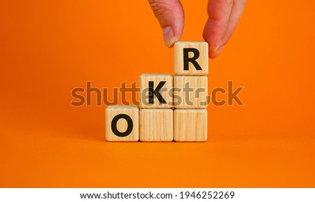 OKR, objectives and key results symbol. Concept words 'OKR, objectives and key results' on cubes on a beautiful orange background. Business, OKR - objectives and key results concept. Copy space.