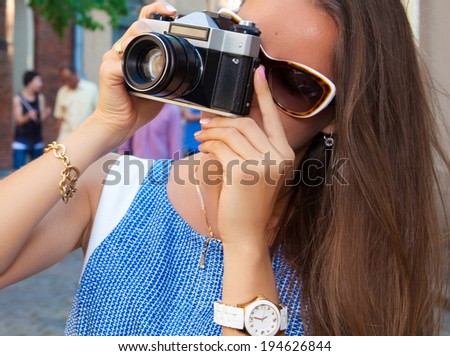 holidays and tourism, technology concept - beautiful girl taking picture in the city