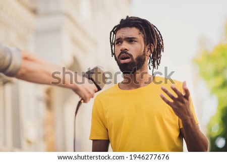 Photo portrait of young man giving interview on street speaking on camera for press television Royalty-Free Stock Photo #1946277676