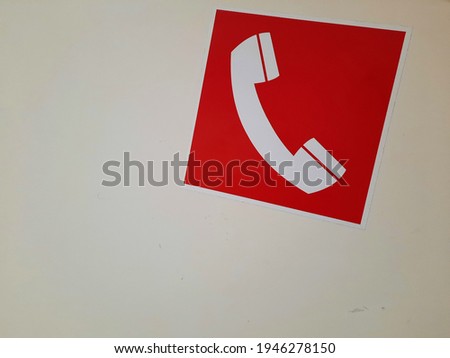 Red telephone sign on white hospital door