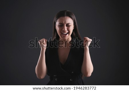 Portrait of emotional young woman on black background. Personality concept
