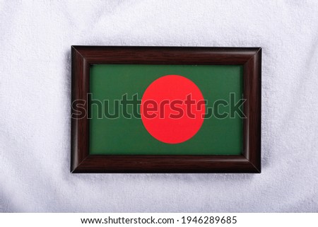 Bangladesh flag in a realistic frame on white cloth background flat lay photo.