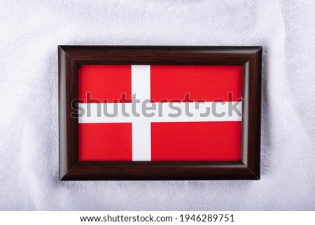 Denmark flag in a realistic frame on white cloth background flat lay photo