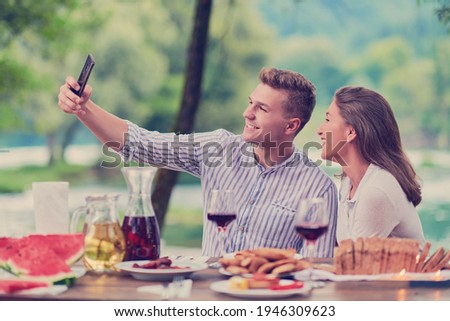 couple taking selfie while having picnic french dinner party outdoor