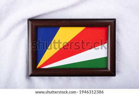 
Seychelles flag in a realistic frame on white cloth background flat lay photo