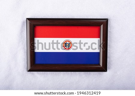 Paraguay Republic flag in a realistic frame on white cloth background flat lay shot