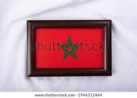 
Morocco flag in a realistic frame on white cloth background flat lay photo