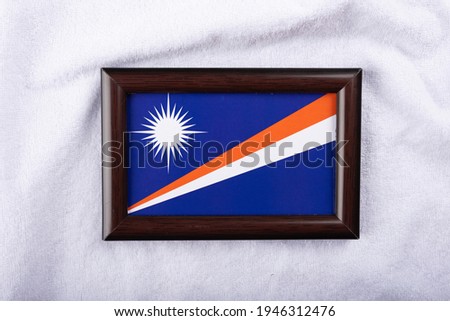 Marshall islands flag in a realistic frame on white cloth background flat lay photo